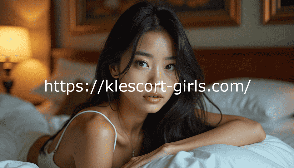 Young Asian woman with dark hair lying on a bed, looking at the camera
